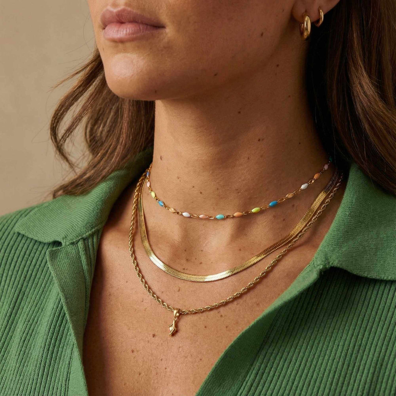 Rainbow Choker featuring colorful enamel beads on a gold chain, styled with layered necklaces by Brother & Sisters.