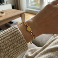 Thumbnail for Love Couple Bracelet with a polished heart on a Cuban link chain by Brother & Sisters, highlighting connection and love.