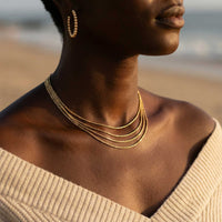 Thumbnail for Riviera Layered Choker by Brother & Sisters, featuring four delicate chains in gold, styled with casual beach wear.