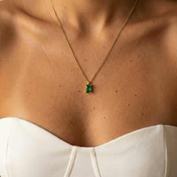 Thumbnail for Emerald Pendant Necklace in gold setting, featuring vibrant green emerald, worn by model with a classic elegant look. Brother & Sisters.
