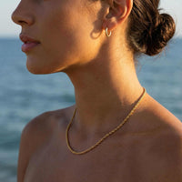 Thumbnail for Rope Chain Necklace worn by a model at the beach, showcasing its classic twisted texture, by Brother & Sisters.