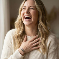 Thumbnail for Happy woman wearing a Wrap Couple Bracelet by Brother & Sisters, showcasing custom engravings.