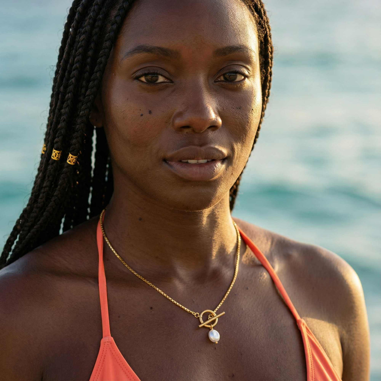 La Isla Pearl Toggle Necklace worn by a model, featuring a geometric gold toggle and freshwater pearl, by Brother & Sisters.