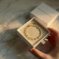 Thumbnail for Double White Bracelet displayed in a box by Brother & Sisters, featuring white enamel beads and gold links.