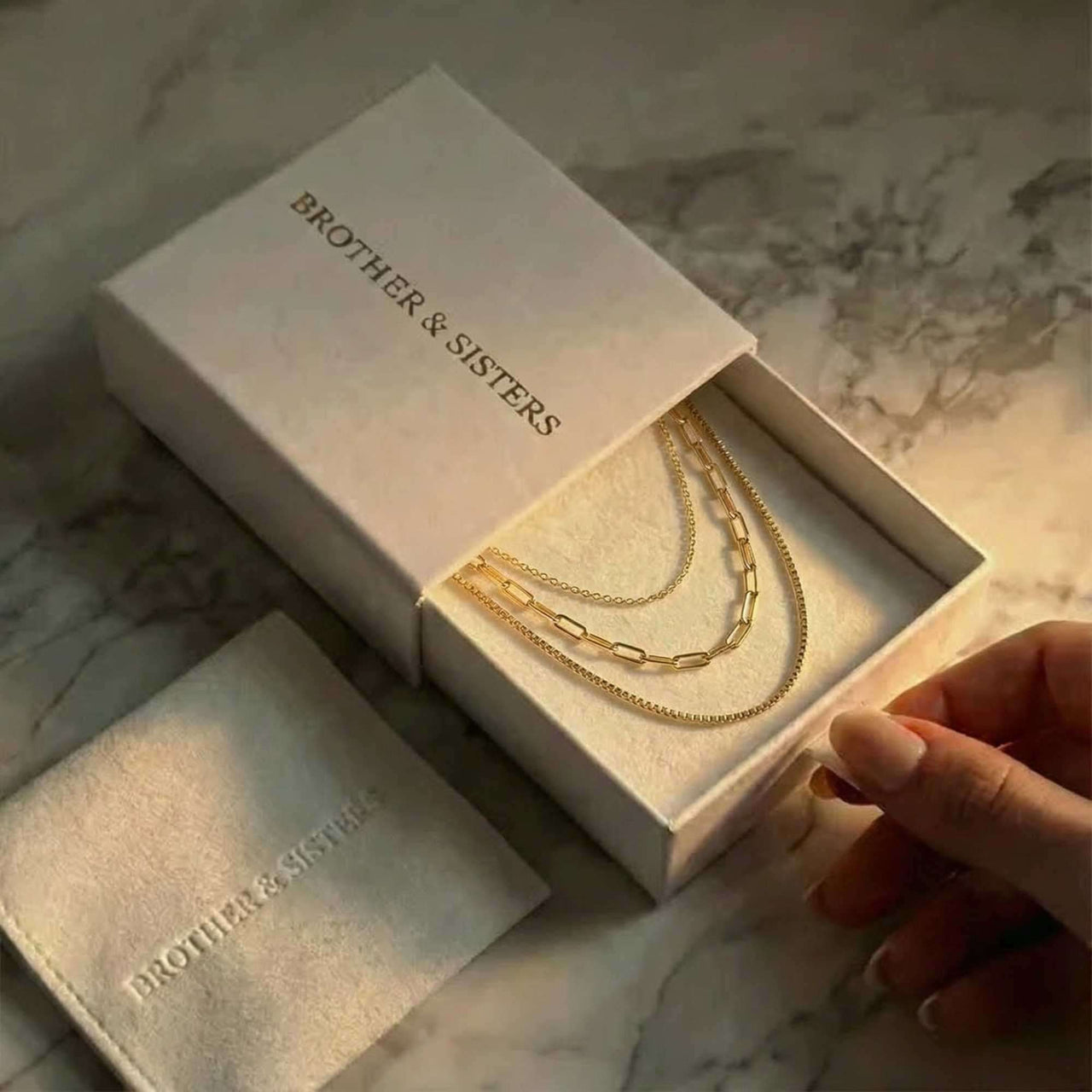 Saona Triple Layer Necklace by Brother & Sisters in a gift box, showcasing three gold chains.
