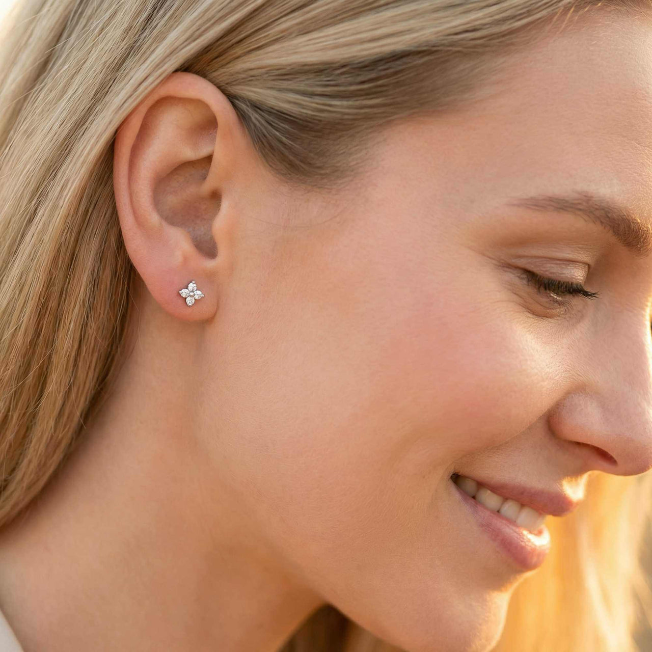 A woman wearing Crystal Flower Stud Earrings by Brother & Sisters, showcasing tiny sparkling flower designs.