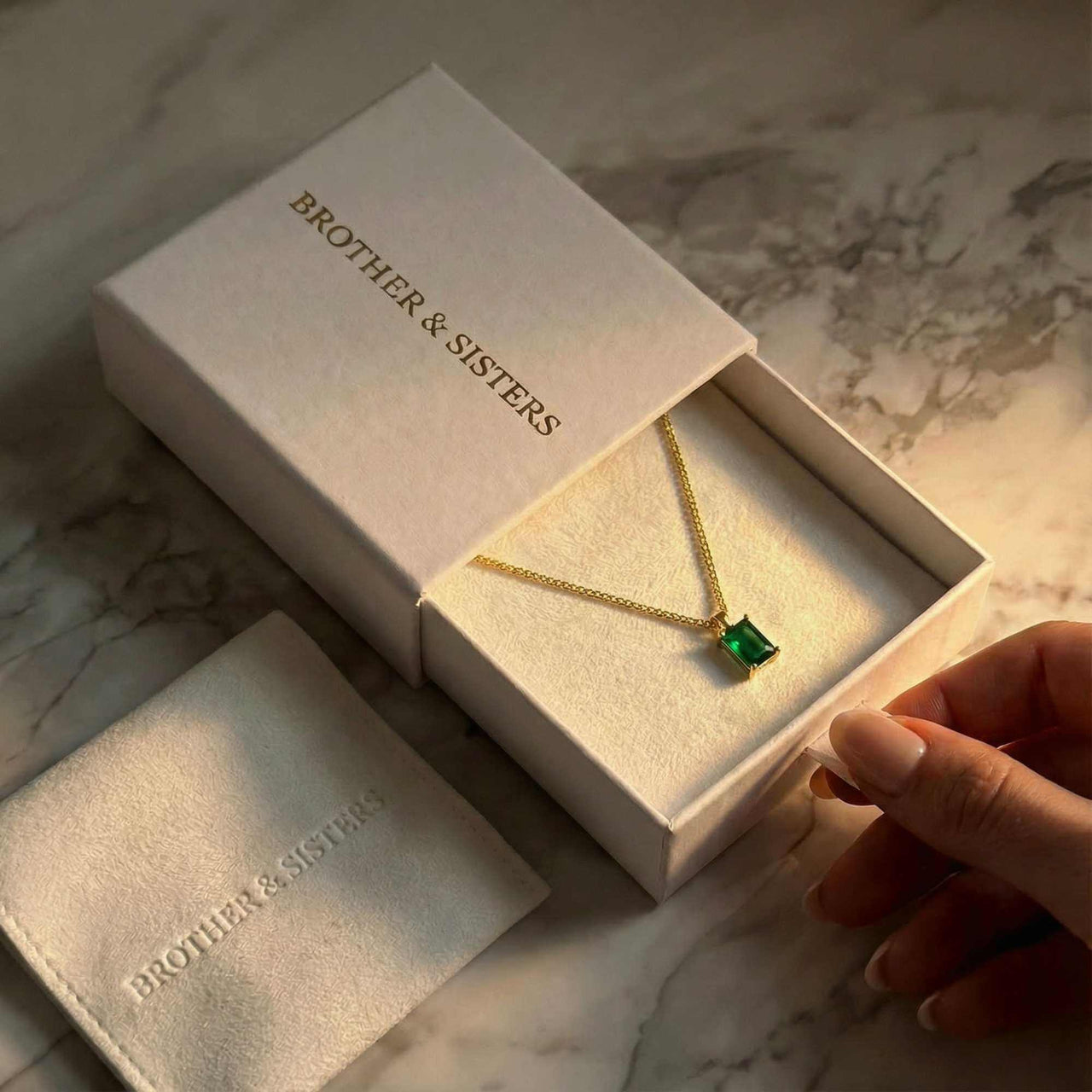Emerald Pendant Necklace in gold setting by Brother & Sisters, presented in elegant packaging.