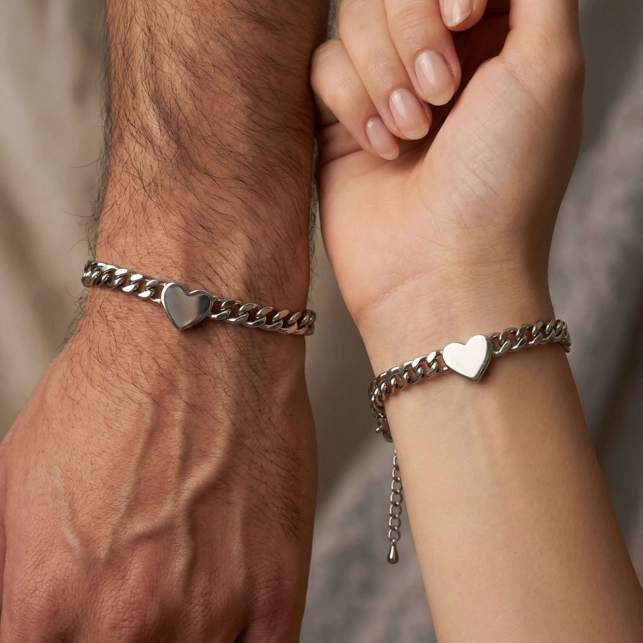 Love Couple Bracelet featuring polished heart on Cuban link chains by Brother & Sisters, symbolizing connection.