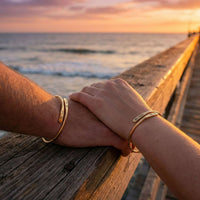 Thumbnail for Wrap Couple Bracelet by Brother & Sisters featuring personalized engravings held by couple at sunset.