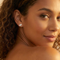 Thumbnail for Crystal Flower Stud Earrings worn by a model, showcasing tiny four-leaf flowers with zirconia stones from Brother & Sisters.