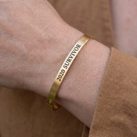 Thumbnail for Close-up of the 2020 Survivor bracelet in gold worn | SKU: 2020s-g