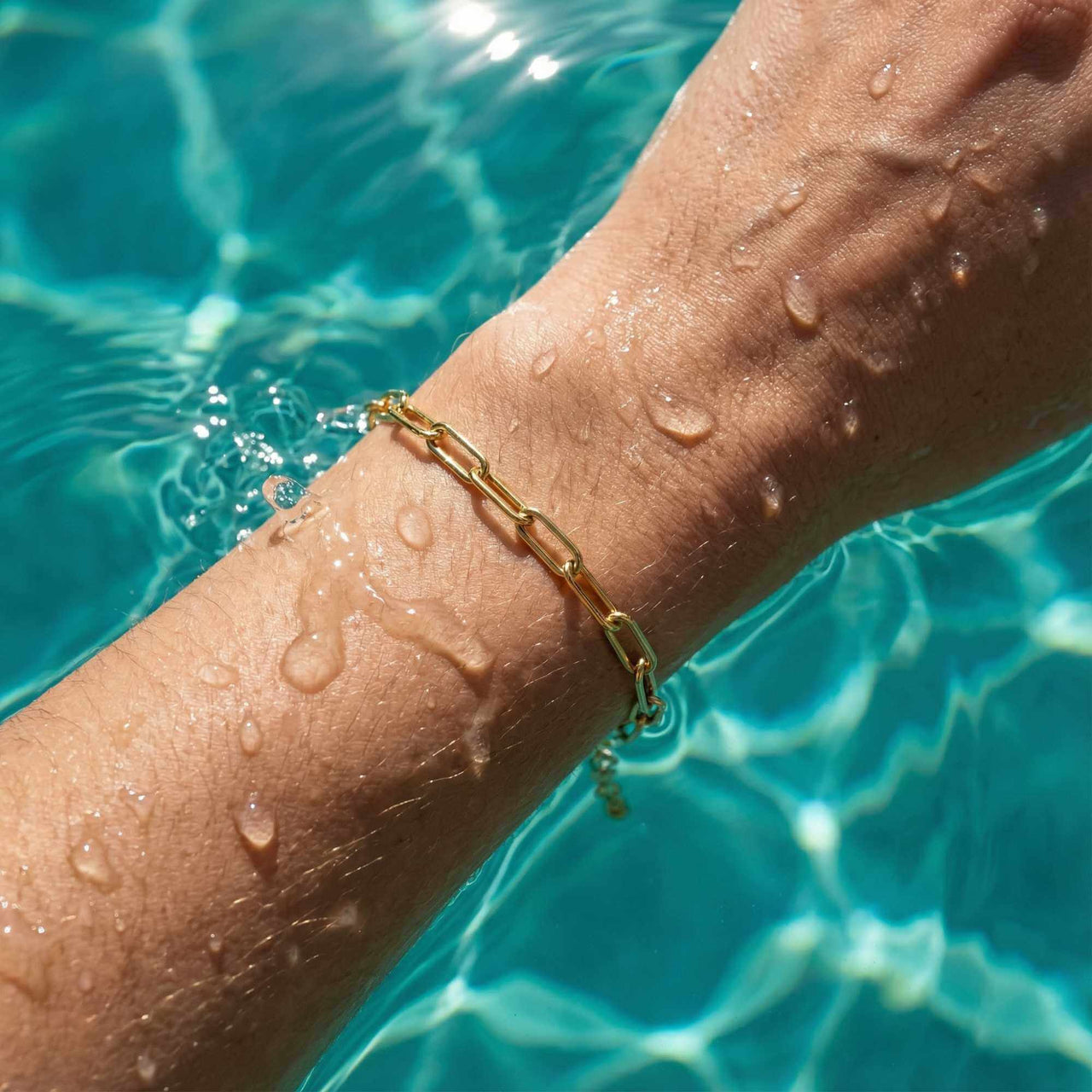 Paperclip Chain Bracelet on a wet wrist, showcasing simple links and 18K gold finish by Brother & Sisters.