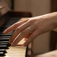 Thumbnail for Hand playing piano wearing a delicate Crystal Flower Ring by Brother & Sisters with four sparkling zirconia stones.