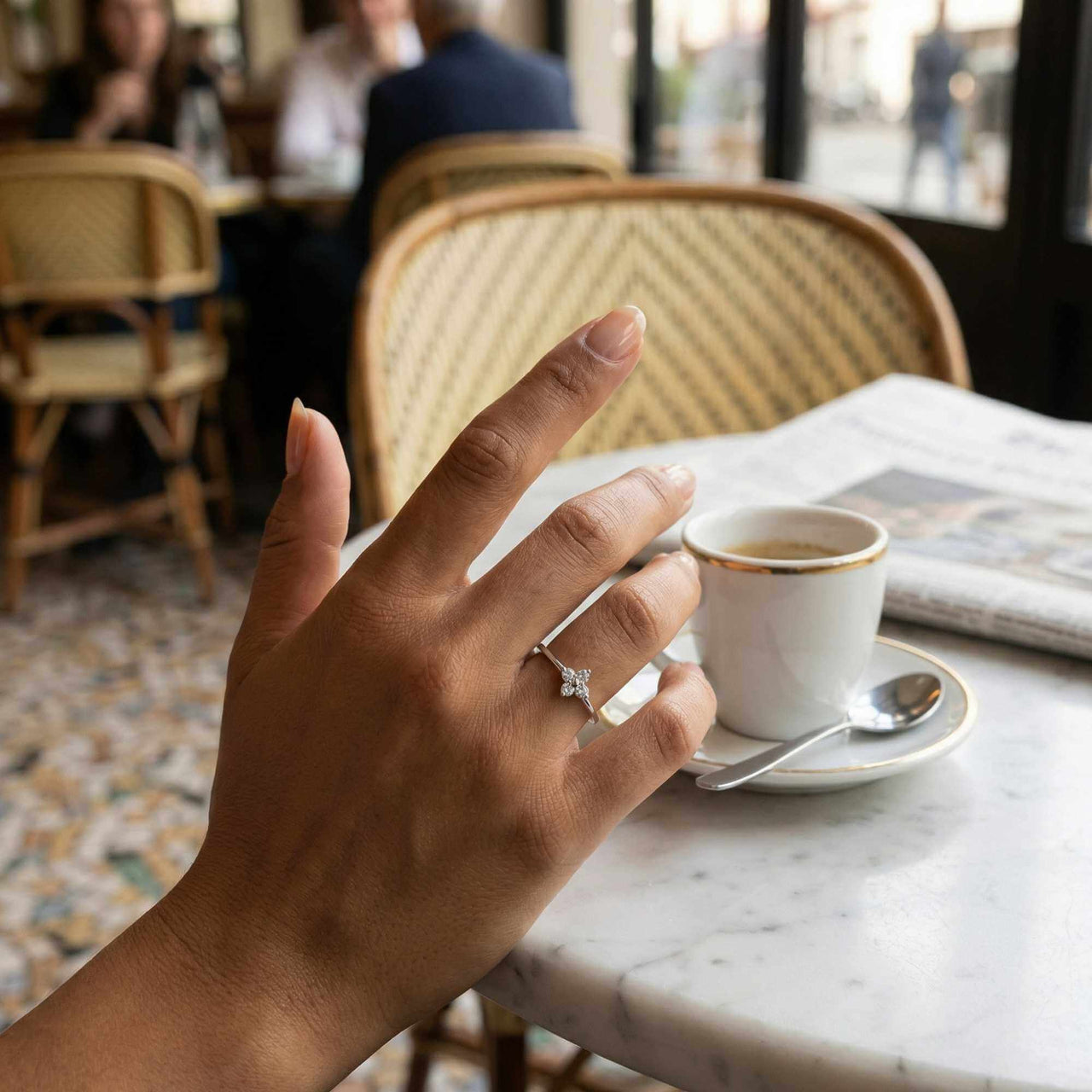Crystal Flower Ring worn on a hand holding a coffee cup, showcasing its delicate design by Brother & Sisters.