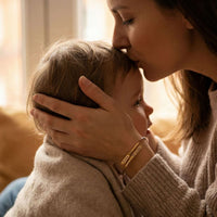 Thumbnail for Wrap Couple Bracelet worn by a mother kissing her child, showcasing love and connection. Brand: Brother & Sisters.