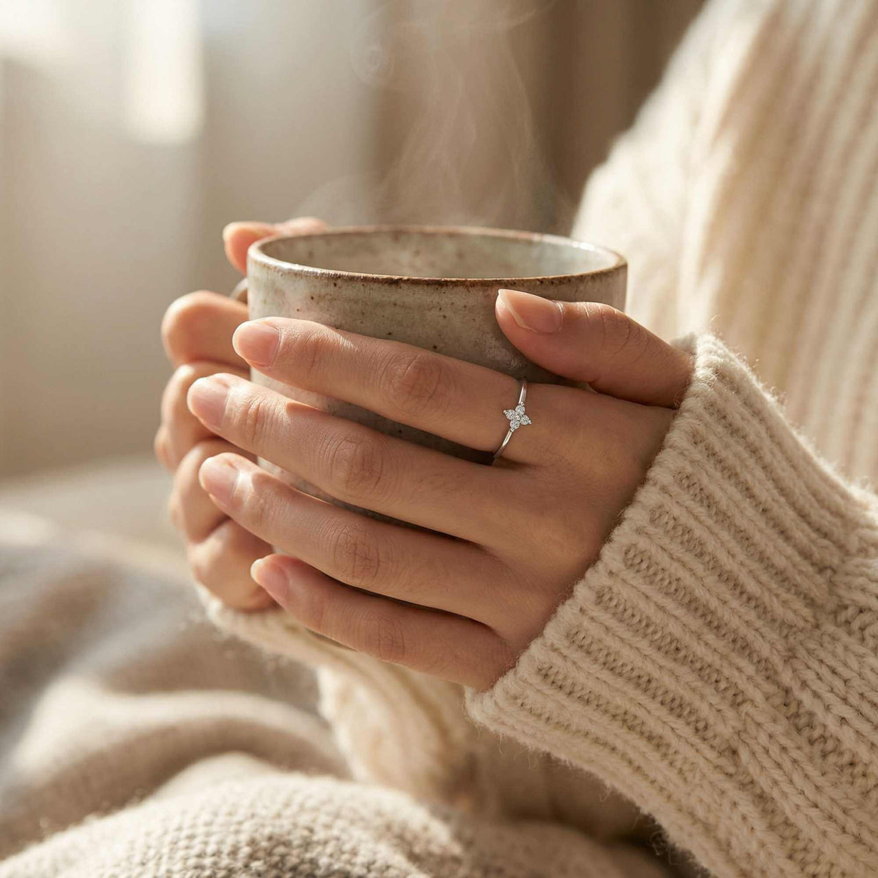 Crystal Flower Ring worn by a person holding a steaming cup, showcasing its delicate design and sparkle.
