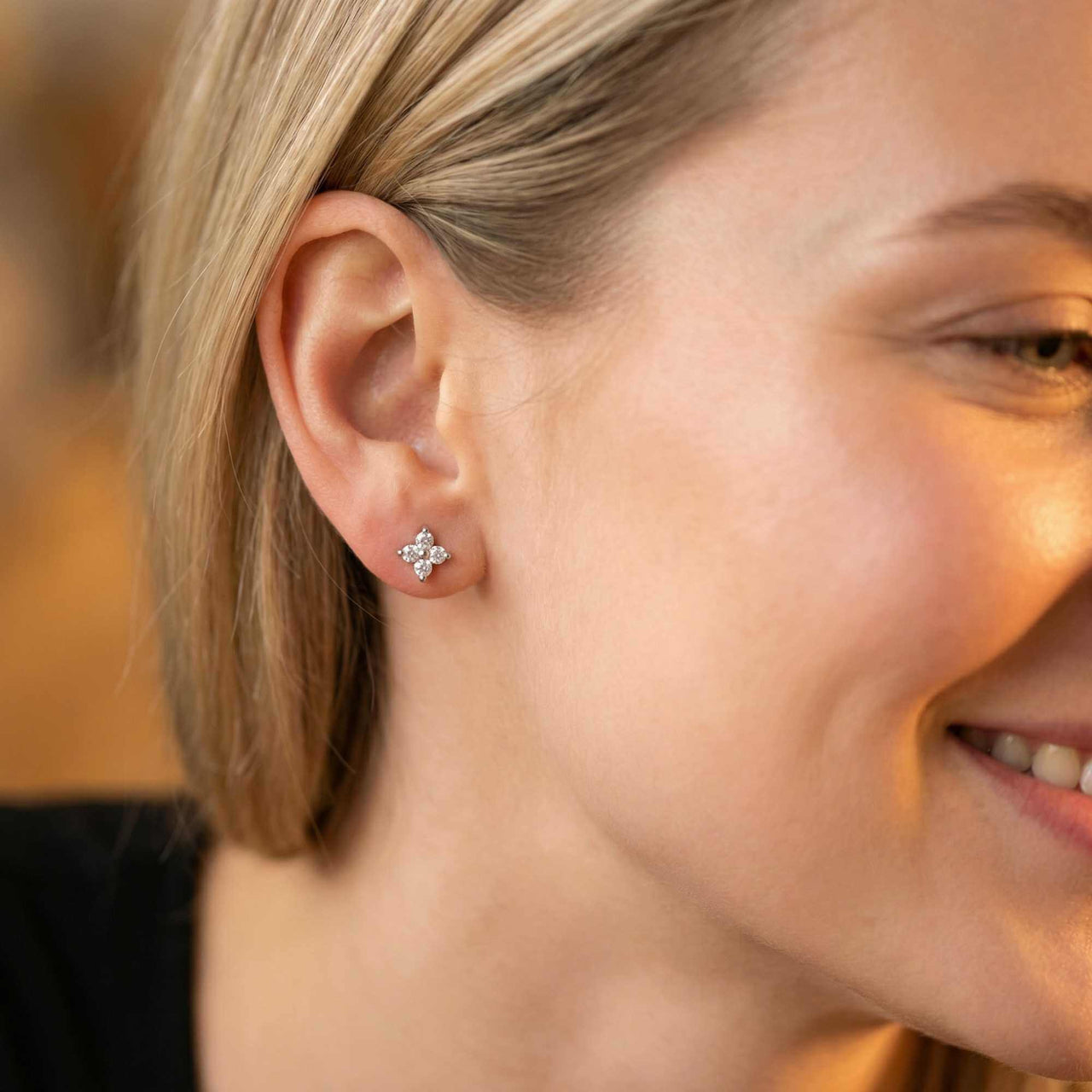Crystal Flower Stud Earrings worn by a woman, showcasing tiny flower design and sparkling zirconia stones by Brother & Sisters.