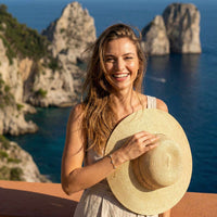 Thumbnail for Woman wearing a straw hat near the coast, showcasing the Crystal Flower Bracelet by Brother & Sisters.
