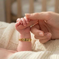 Thumbnail for Infant Bracelet by Brother & Sisters featuring personalized name 'Amara' on a baby's wrist with a gentle hand.