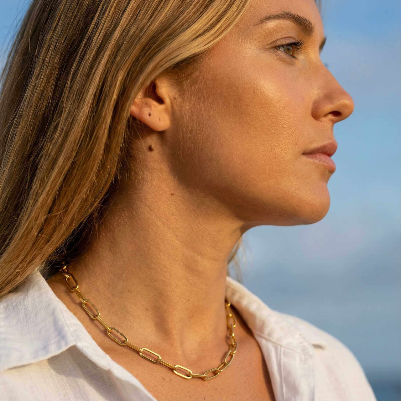 Model showcasing Ria Paperclip Chain Necklace by Brother & Sisters, featuring bold oversized links in 18K gold PVD.