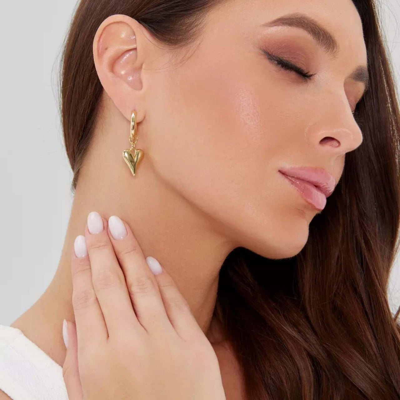Amora Heart Drops gold earrings showcased on a model, featuring elongated heart charm and sleek hoop by Brother & Sisters.