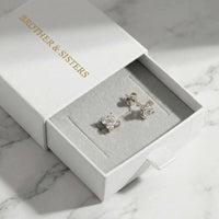 Thumbnail for Crystal Flower Stud Earrings in a branded Brother & Sisters box, showcasing tiny four-leaf zirconia designs.