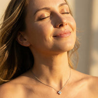 Thumbnail for Model wearing Crystal Flower necklace — dainty four-leaf zircon flower pendant at collarbone, minimalist refined