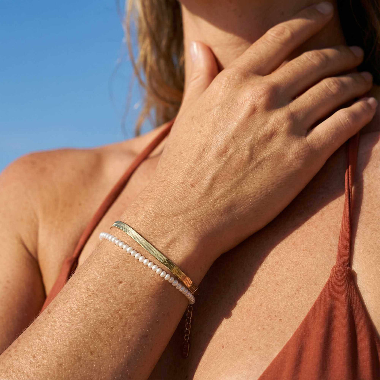 Kauai Herringbone Bracelet worn on a woman's wrist, featuring a sleek design with premium materials by Brother & Sisters.