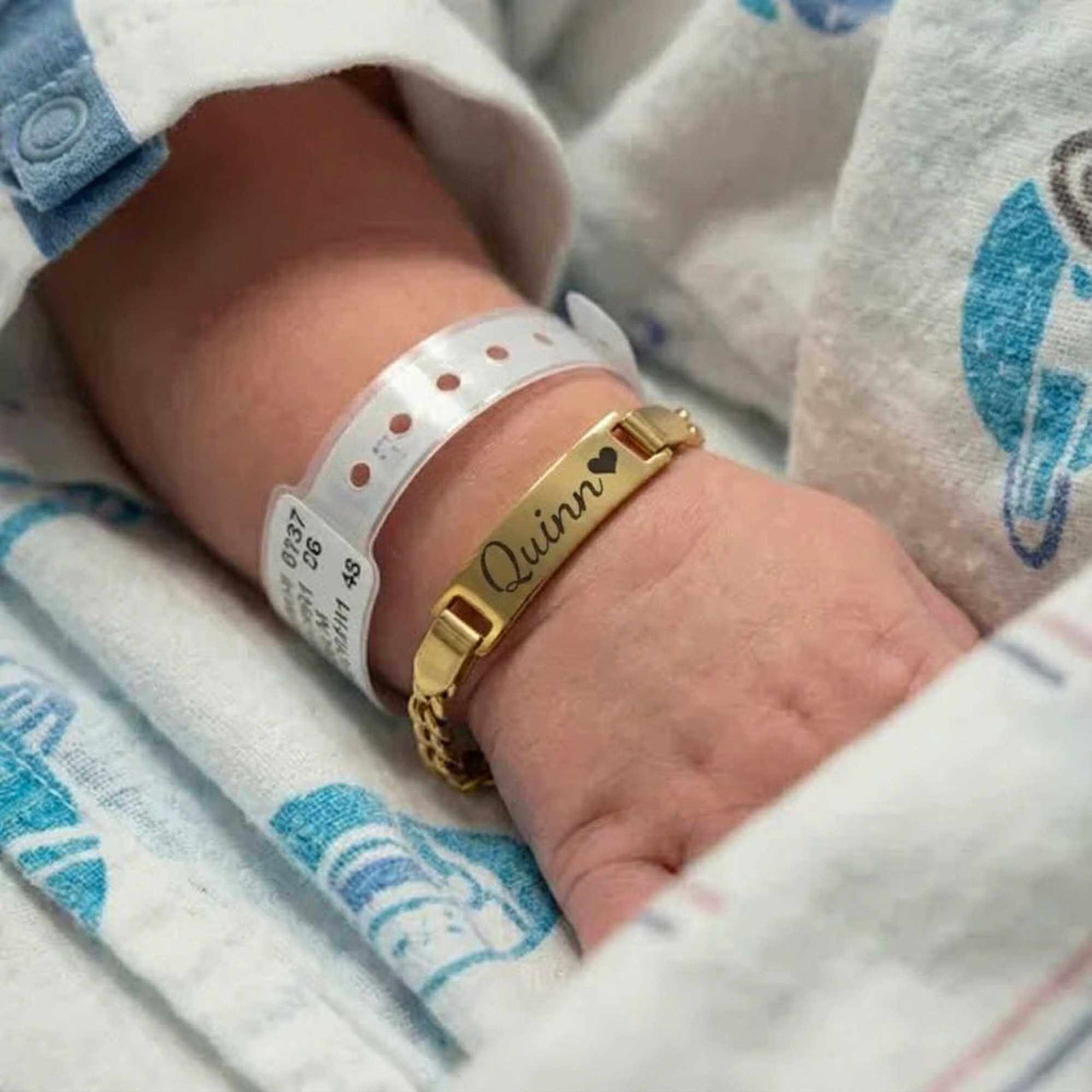 Infant Bracelet featuring a golden personalized name plate with the name Quinn, by Brother & Sisters.