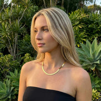 Thumbnail for The Golden Statement necklace by Brother & Sisters showcased on a model in nature, highlighting its elegant design.