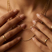 Thumbnail for Saona Triple Layer Necklace by Brother & Sisters featuring three gold chains of varying lengths.