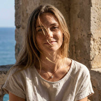Thumbnail for Crystal Flower necklace worn by woman with long hair, dainty pendant adding refined elegance against neckline