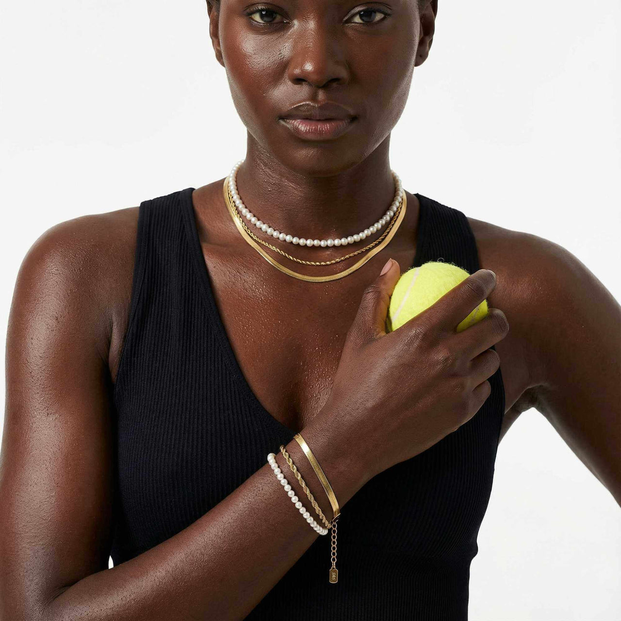 Calvi Rope Chain Bracelet worn with layered necklaces and holding a tennis ball, by Brother & Sisters.
