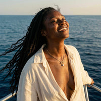 Thumbnail for La Isla Pearl Toggle Necklace worn by a woman on a boat, showcasing its unique toggle clasp and freshwater pearl detail.