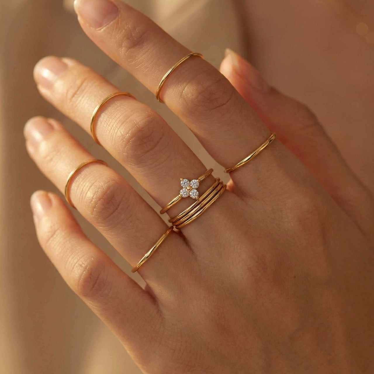 Crystal Flower Ring with zirconia stones worn on delicate fingers, featuring gold bands by Brother & Sisters.