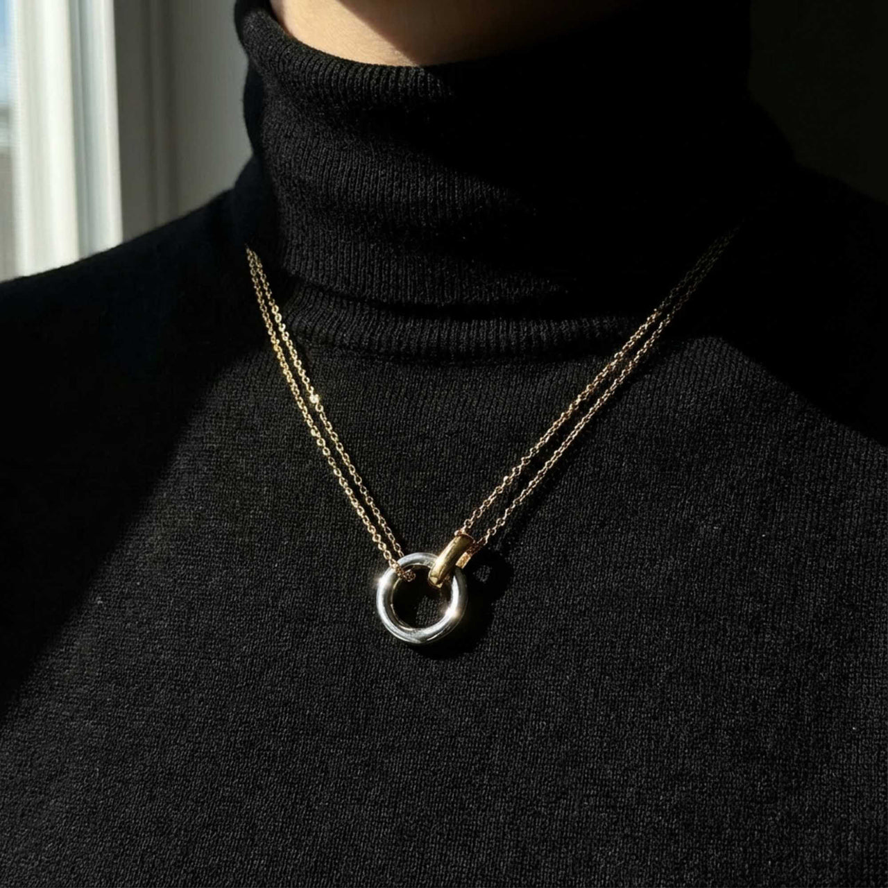 The Unity Bond necklace by Brother & Sisters featuring a silver circle and gold bar in a sophisticated design.