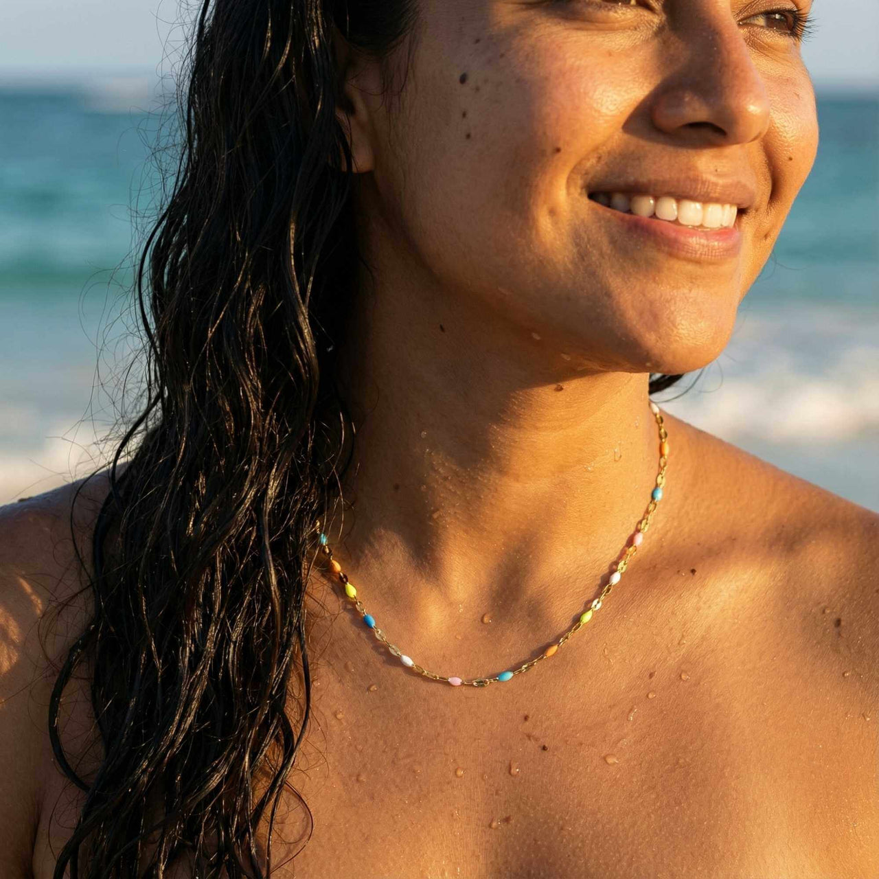 Rainbow Choker worn on a model at the beach, featuring colorful hand-painted enamel beads by Brother & Sisters.