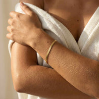 Thumbnail for Kauai Herringbone Bracelet on a woman's wrist, showcasing its sleek design and 18K gold PVD finish by Brother & Sisters.