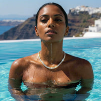 Thumbnail for Isolde Tennis Necklace worn by a woman in a pool, featuring diamond simulants in 18K gold, by Brother & Sisters.