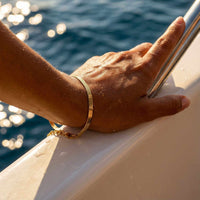 Thumbnail for Kauai Herringbone Bracelet on a hand, showcasing its sleek design and liquid-gold shimmer by Brother & Sisters.