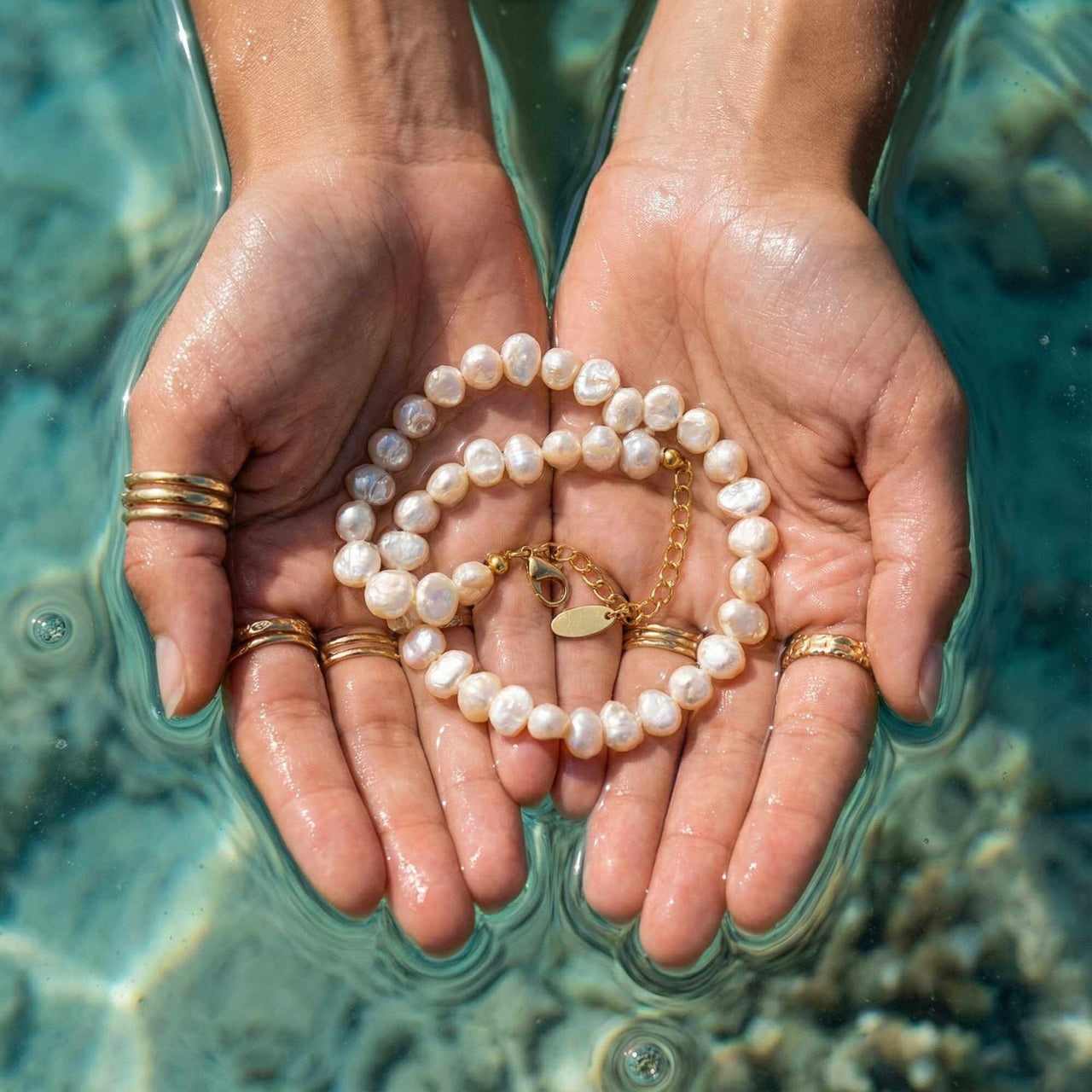 Sunseeker Pearl Choker by Brother & Sisters showcasing irregular baroque pearls on a golden chain in hands.