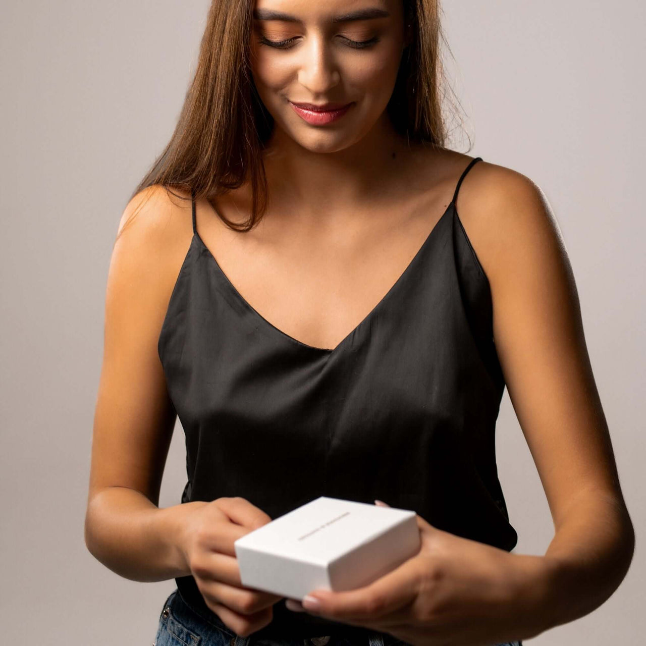 Woman unboxing the Pink Photo Bracelet by Brother & Sisters, showcasing its elegant packaging.