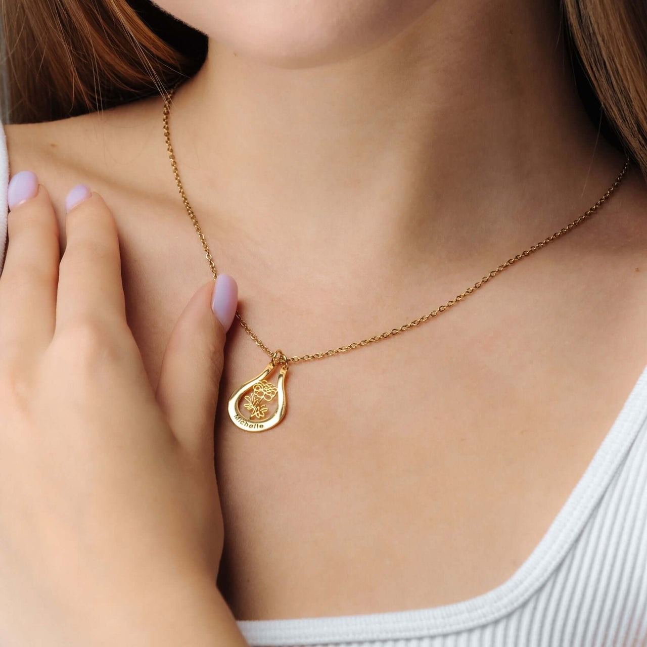 Close-up of a woman wearing a Birth Flower Name Necklace by Brother & Sisters, featuring a gold charm.
