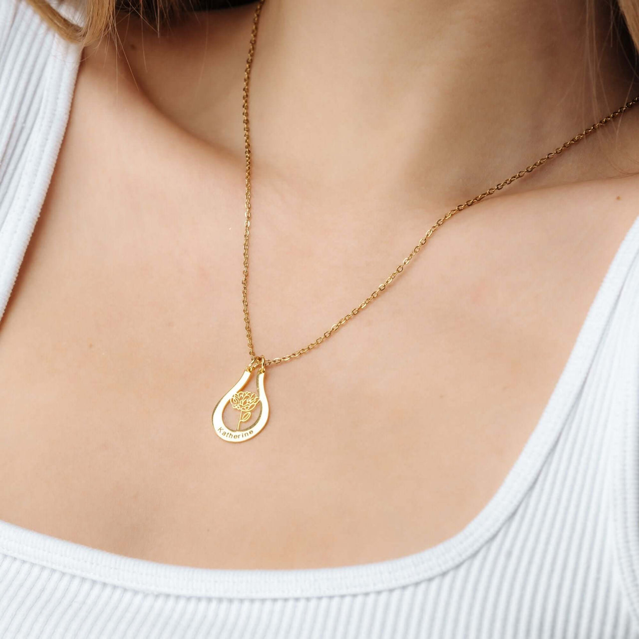 Birth Flower Name Necklace from Brother & Sisters showcasing a delicate gold pendant worn on a woman's neck.