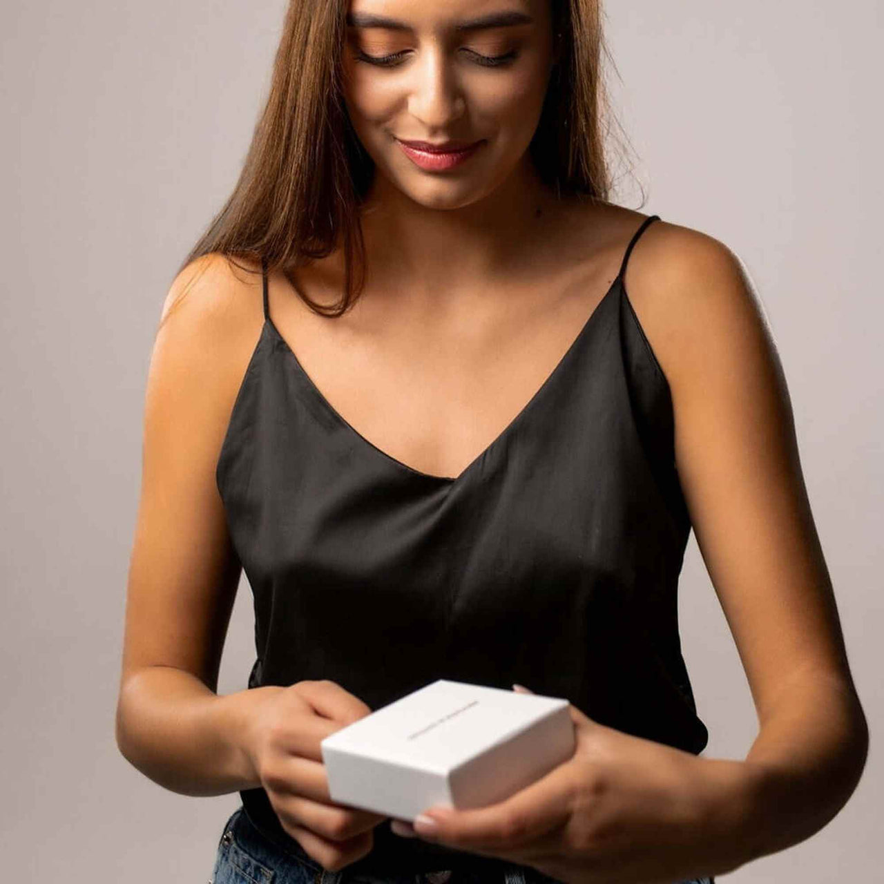 Woman unboxing a Love Photo Necklace from Brother & Sisters, showcasing a personalized keepsake.