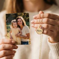 Thumbnail for Precious Name Necklace held by a person showing a photo, featuring a personalized 'Mom' pendant with a birthstone, by Brother & Sisters.