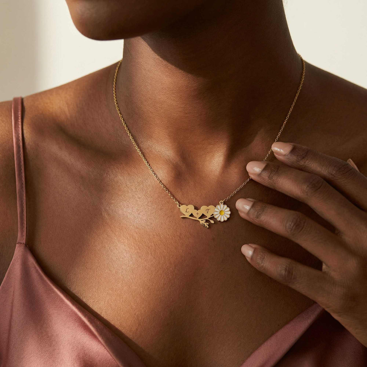 Daisy Name Necklace by Brother & Sisters featuring three connected hearts and a delicate white enamel daisy.