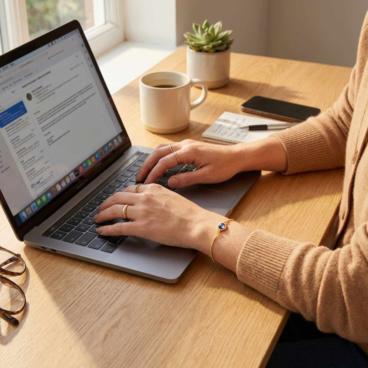 Person using a laptop while wearing a Photo Projection Bracelet by Brother & Sisters, capturing special memories.