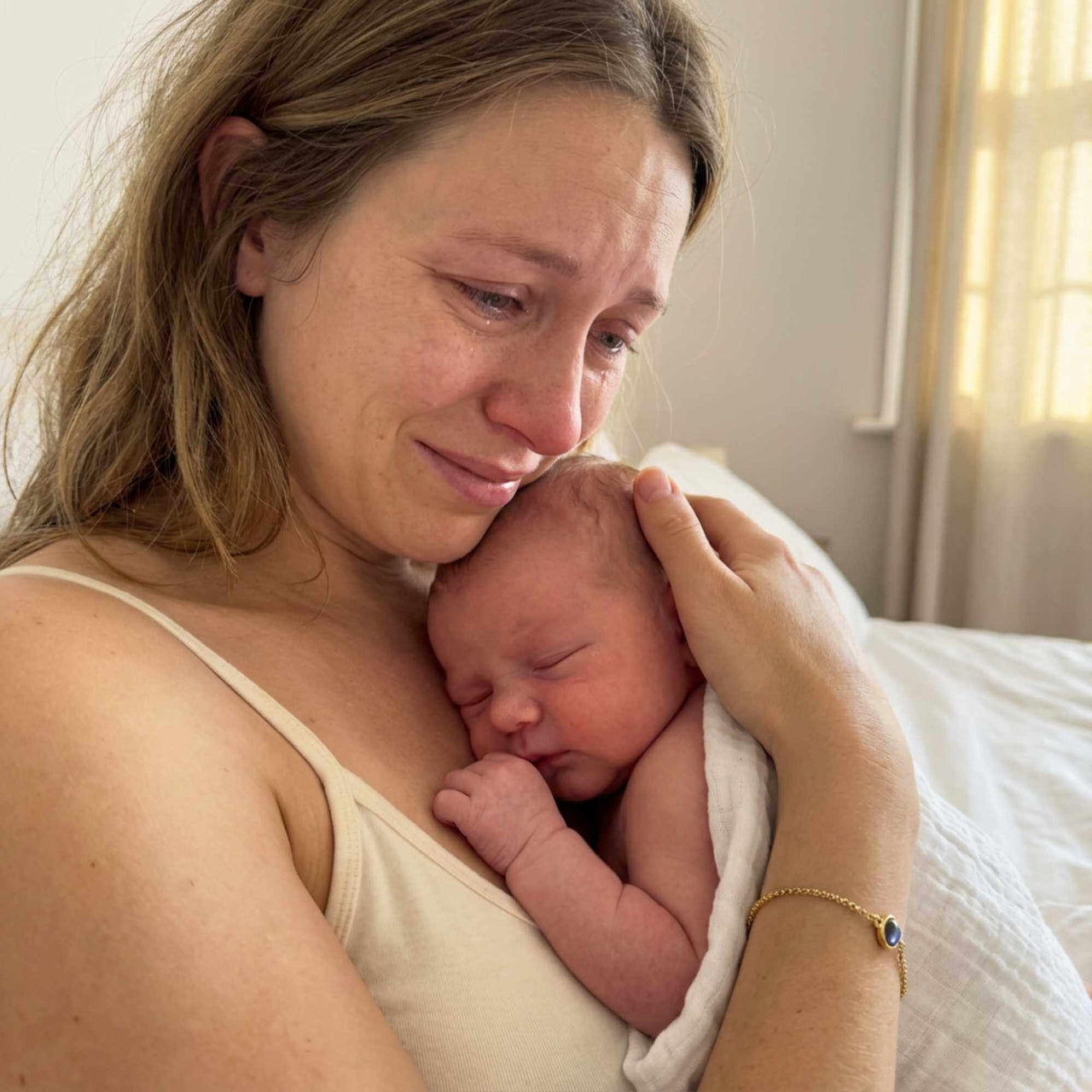 Emotional moment of a mother holding her newborn baby, showcasing love and connection.