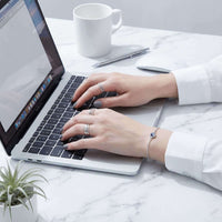 Thumbnail for Photo Projection Bracelet worn by a woman typing on a laptop, showcasing its elegant design by Brother & Sisters.